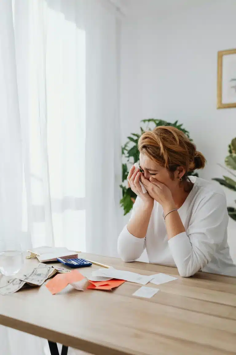 une femme assise à son bureau en pleur